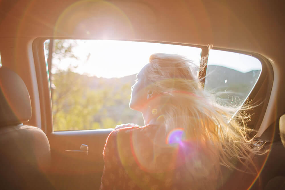 A woman illuminated by sunlight through a  car window
